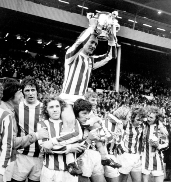 Peter Dobing lifts the trophy